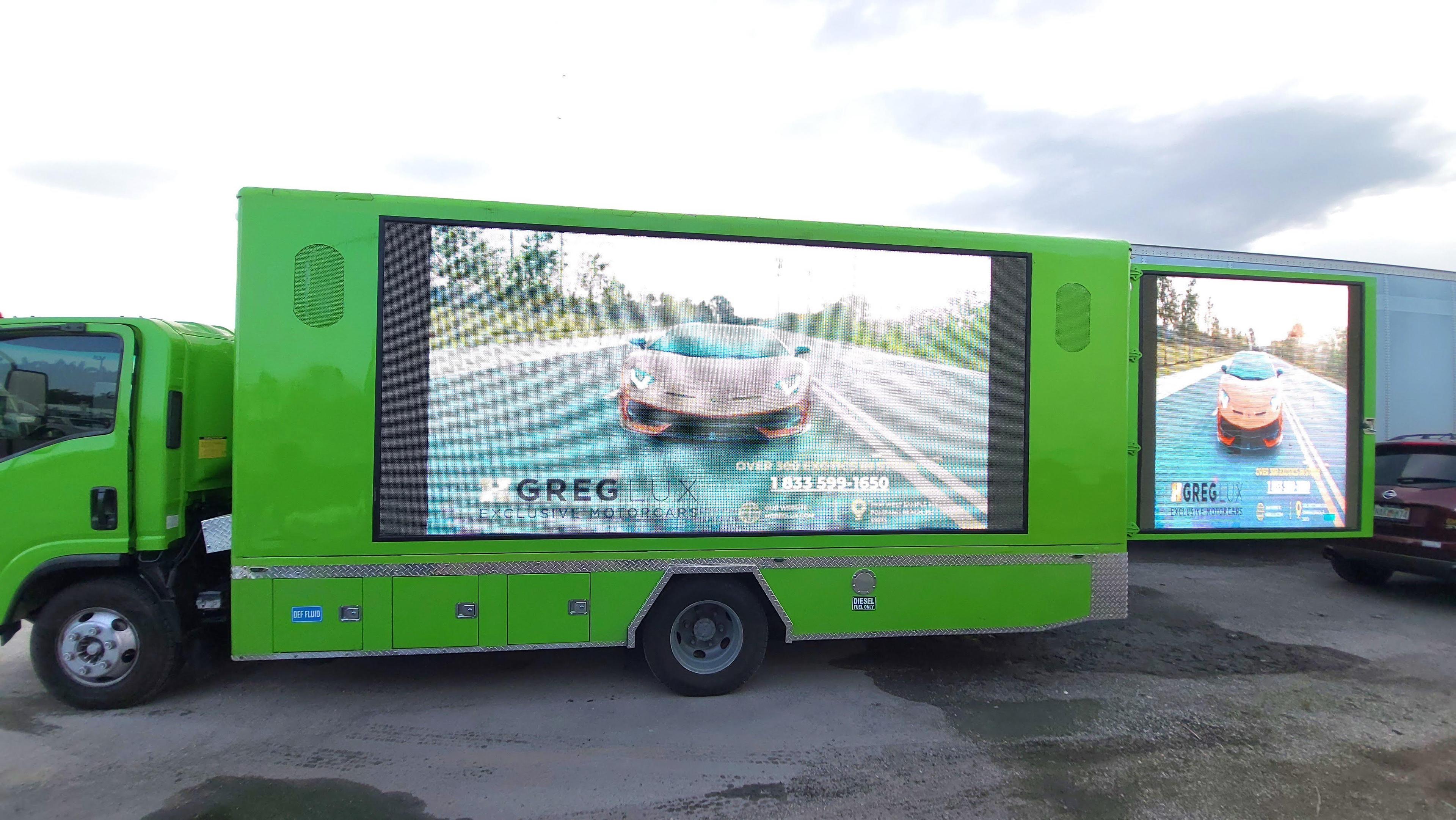 green truck with billboard in it 