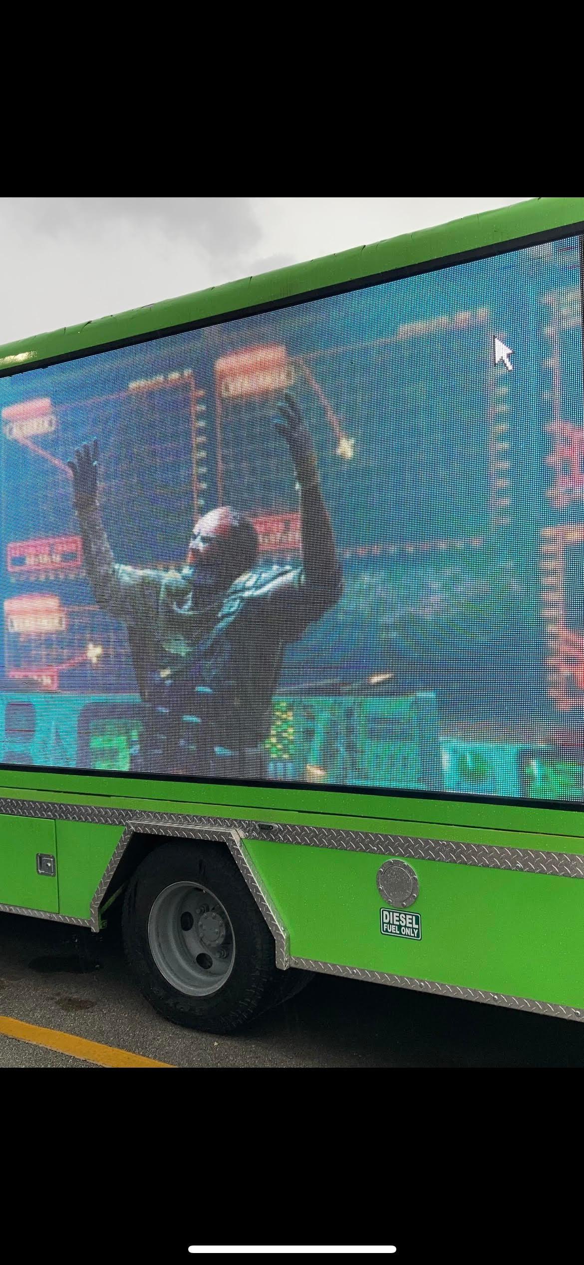 green truck with billboard in it 